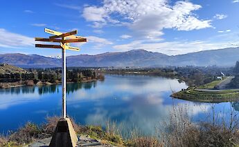 Signpost with Cromwell in the distance, New Zealand. CC:N Z Biketrails
