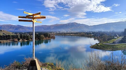 Signpost with Cromwell in the distance, New Zealand. CC:N Z Biketrails
