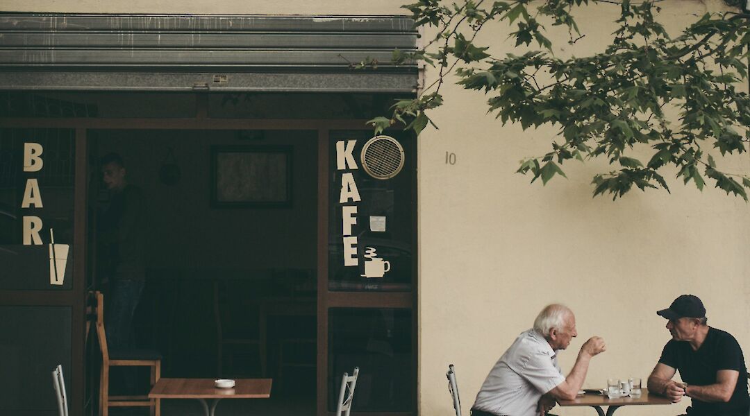 Older gentlemen dining al fresco, Durres, Albania. Juri Gianfrancescojpg@Unsplash