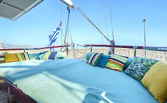 Spacious deck area with colorful cushions and a Greek flag in the background, suggesting a relaxing&hellip;