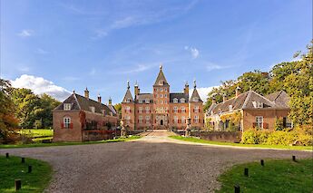 A grand castle with multiple turrets and a symmetrical layout, set against a clear blue sky in the province of Utrecht, Netherlands.