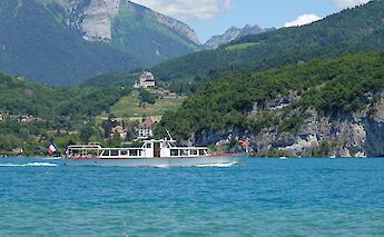 Ferry service on Lake Annecy with Château de Menthon-Saint-Bernard in the background. CC:Guilhem Vellut