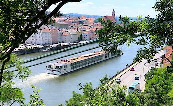 A boat cruising past Passau, Germany. Unsplash:Andi Steiner