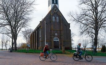 Cycling past a rural church outside Amsterdam, Holland bike tour. CC:TO