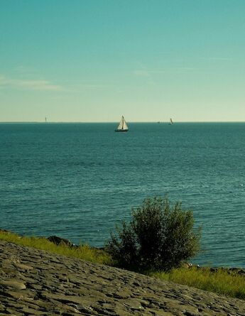 A sailboat in the distance in Urk, Holland. Willy the Wizard@Unsplash