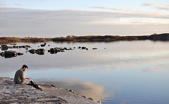 Man sitting beside Lough Mask, Galway, Ireland. Neil Ward@Flickr