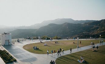 View from the Griffith Observatory in Los Angeles, with people on the terrace and hills in the background.