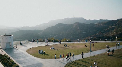 View from the Griffith Observatory in Los Angeles, with people on the terrace and hills in the background.
