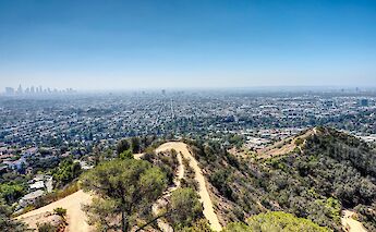 Aerial view of Los Angeles from the Griffith Observatory, featuring sprawling cityscape and nearby hills.