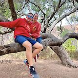 Couple sitting in a tree near the waterfall, Malibu, California, USA. CC:LifeRush Adventures