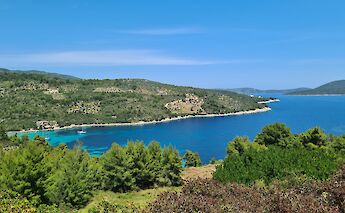 A scenic view of Alonissos Island in Greece, featuring lush greenery and azure waters.