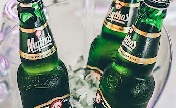 Four bottles of Mythos beer on ice in a bucket.