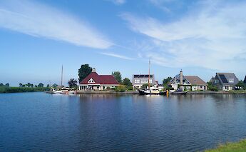 A canal in Friesland lined with traditional Dutch houses. to-BBT
