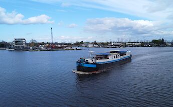 The boat "La Mar" is navigating through a waterway with buildings and a crane visible on…