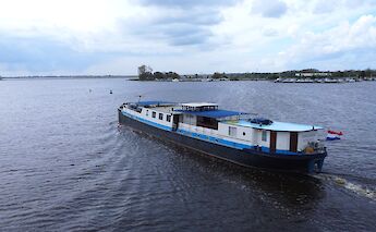 The boat "La Mar" is seen moving through a body of water under a cloudy sky.
