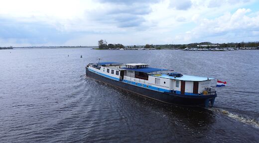 The boat "La Mar" is seen moving through a body of water under a cloudy sky.