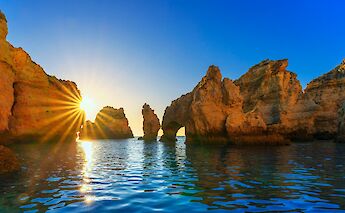 Sunset over the rocks in Lagos, Portugal bike tours. Getty Images@Unsplash