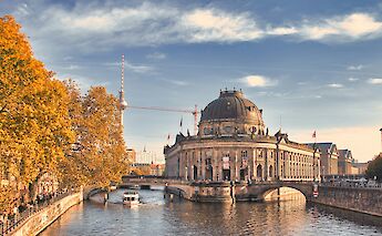 The river flowing around Museum Island in Berlin, Germany, with the Bode Museum and Berlin TV Tower in the background.