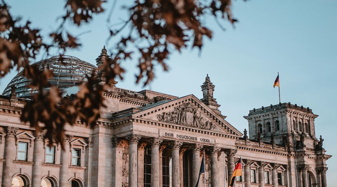 The Reichstag viewed through foliage, Berlin, Germany. Yannic Kress