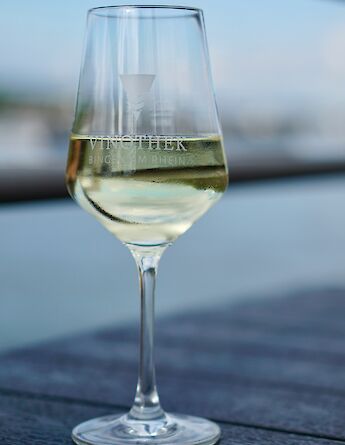Glass of white wine, Bingen am Rhein, Germany. Unsplash:Luca J