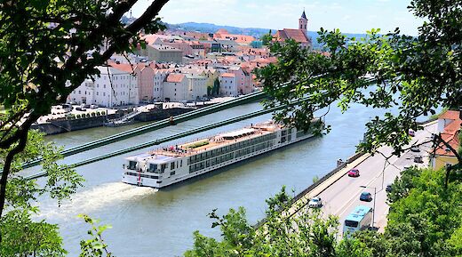 Boat cruising through Passau, Germany. Unsplash:Andi Steiner