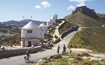 Cycling past windmills, Island of Leros, Greece. CC:Island Hopping