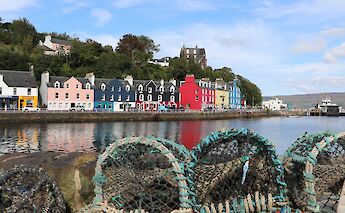 2. A row of colorful houses along the waterfront in Tobermory, Scotland, with fishing nets in the foreground.