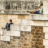 People reading on ancient walls, Paris, France. Viktor Kiryanov@Unsplash