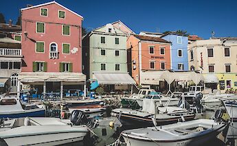 Multi-colored buildings by the harbor, Losinj, Croatia. Unsplash:Ante Hamersmit