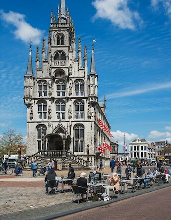 People sitting outside St. John's Church, Gouda, Holland. Unsplash:David Martinez Torres