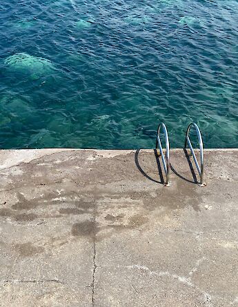 Ladder into the sea, Salina, Italy. Unsplash:Emma Dickopf