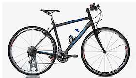 A black touring bike with a water bottle mounted on the frame, showcasing a sleek design with drop handlebars and white-rimmed wheels.