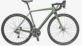 A green gravel bike with a lightweight frame and drop handlebars, featuring disc brakes and rugged tires.