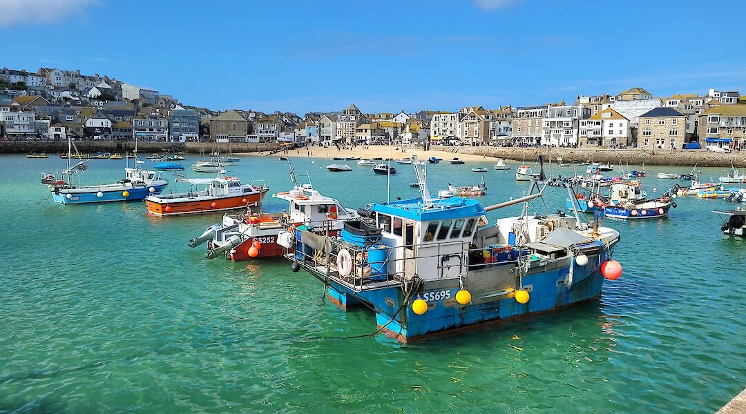 Brightly colored boats moored in St Ives harbor. Link Bekka@unsplash