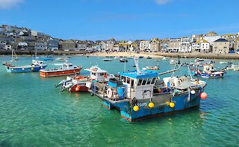 Brightly colored boats moored in St Ives harbor. Link Bekka@unsplash