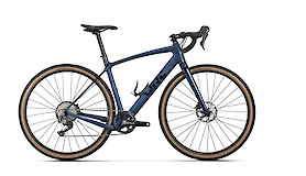 A blue gravel bike with drop handlebars and light-colored tires, suitable for mixed surfaces.