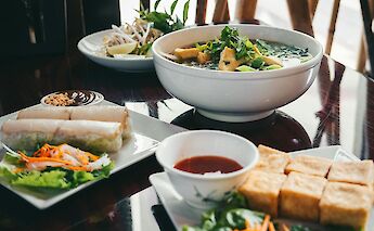 Vietnamese meal with spring rolls, tofu, and noodle soup. Alteredsnaps@pexels
