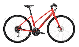A red standard touring bike with a lightweight frame and disc brakes, designed for road cycling and touring.