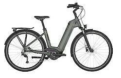 A grey electrically-assisted bicycle with a step-through frame, featuring fenders and a rear rack, suitable for city commuting and leisure rides.