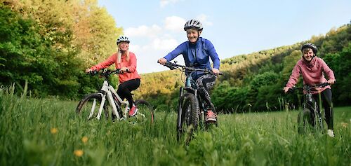 Three women cycling through a field. Getty Images@Unsplash