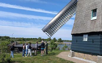 Bike tour next to a windmill at Zaanse Schans, Amsterdam e-bike tour. CC:TO