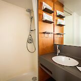 Modern en-suite bathroom with shower, sink, and thoughtful storage for everyday comfort.
