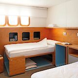 A bright and comfortable twin cabin, thoughtfully designed with smart storage and a warm, modern finish.