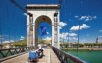 Cycling across a bridge over the Rhône River. toST