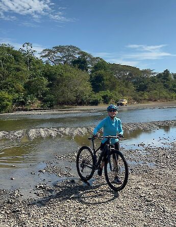 Cycling across a river crossing on remote backroads. cc-Heather