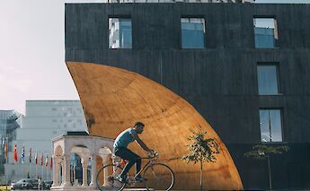Man cycling through Tirana, Albania. Alexandr Bormotin@Unsplash