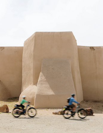 Cycling past huge walls on the Taos e-bike tour, New Mexico, USA. CC:TO